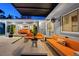 An outdoor lounge with a pergola, fire pit, seating, and a view of an open bedroom through sliding glass doors at 222 N Clearview Ave, Tampa, FL 33609