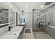 A modern bathroom features dual sinks, LED mirrors, and a glass shower at 222 N Clearview Ave, Tampa, FL 33609
