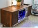 A vintage entertainment center converted into a stylish bar with illuminated glass storage at 222 N Clearview Ave, Tampa, FL 33609