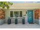 Stylish teal front door framed by modern planters, contrasting with the brick and gray exterior at 222 N Clearview Ave, Tampa, FL 33609