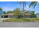 Charming single story brick home with mature landscaping, a driveway, a carport, and an attached garage at 222 N Clearview Ave, Tampa, FL 33609