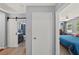 Hallway view showcasing a bathroom with a sliding barn door and a bedroom with a ceiling fan at 222 N Clearview Ave, Tampa, FL 33609