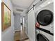 Hallway featuring laundry area, a sliding barn door, artwork and access to other areas of the house at 222 N Clearview Ave, Tampa, FL 33609