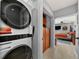 Modern laundry area with a stacked washer and dryer, and a peek into a bedroom at 222 N Clearview Ave, Tampa, FL 33609