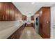 Well-lit kitchen showcasing stainless appliances, granite countertops, shaker cabinets, and refinished terrazzo floors at 222 N Clearview Ave, Tampa, FL 33609