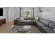 Living room featuring a large gray sectional, mid-century modern furniture, and refinished terrazzo flooring at 222 N Clearview Ave, Tampa, FL 33609
