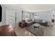 Bright living room showcasing a gray sectional, modern lighting, and refinished terrazzo flooring at 222 N Clearview Ave, Tampa, FL 33609