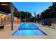 Backyard pool with a cozy seating area and inviting blue lighting at 222 N Clearview Ave, Tampa, FL 33609