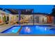 An inviting pool area at twilight, showcasing an outdoor kitchen, seating, and a built-in lounge at 222 N Clearview Ave, Tampa, FL 33609