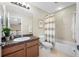 Neutral bathroom features a shower-tub combo with a shower curtain, sink with a dark countertop, and tile flooring at 2527 Silverback Ct, Palm Harbor, FL 34684
