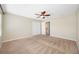 Spacious bedroom with neutral walls, carpet flooring, a ceiling fan, and a view of the bathroom at 2527 Silverback Ct, Palm Harbor, FL 34684