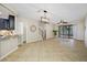 Open-concept living room features neutral tones, tile floors, and a sliding glass door to the patio at 2527 Silverback Ct, Palm Harbor, FL 34684