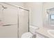 Bright bathroom featuring a glass-enclosed shower, toilet, vanity, and mirror at 2602 Novack Ct, Sun City Center, FL 33573