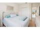 Well-lit bedroom featuring light-blue bedding, wood floors, and a view into the living area at 2602 Novack Ct, Sun City Center, FL 33573