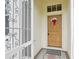 Close-up of a wood front door with a red bow and security gate at 2602 Novack Ct, Sun City Center, FL 33573