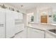 Clean white kitchen with modern appliances and a view towards the living area at 2602 Novack Ct, Sun City Center, FL 33573