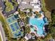 An aerial view of the community's large pool with lounge chairs, pickleball courts, and parking at 2602 Novack Ct, Sun City Center, FL 33573