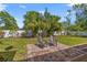 Spacious backyard with a brick patio, two chairs, green grass, and trees under a blue sky at 300 22Nd S Ave, St Petersburg, FL 33705