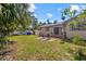 Large backyard with a brick patio, seating, lush grass, and mature trees, perfect for outdoor living at 300 22Nd S Ave, St Petersburg, FL 33705