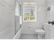 The bathroom has a tub, shower, toilet, and window for natural light at 300 22Nd S Ave, St Petersburg, FL 33705