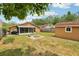 Backyard featuring a shed, cozy firepit, screened-in patio and lush green lawn at 3176 Duane Ave, Oldsmar, FL 34677
