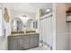 Updated bathroom with granite countertop, grey cabinetry, double sinks, and a shower with curtain at 3176 Duane Ave, Oldsmar, FL 34677
