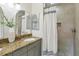 Bathroom showcasing granite countertop, undermount sink, grey cabinetry, and tiled walk-in shower at 3176 Duane Ave, Oldsmar, FL 34677