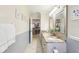 Long bathroom with granite countertop, double sinks, and views of the kitchen through an open doorway at 3176 Duane Ave, Oldsmar, FL 34677