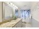 Bathroom featuring a granite countertop, white cabinetry, double sinks, and a blue-themed shower curtain at 3176 Duane Ave, Oldsmar, FL 34677