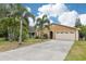 Charming single-story home featuring a well-manicured lawn, palm trees, and a two-car garage at 3176 Duane Ave, Oldsmar, FL 34677