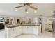 Open kitchen design with an island, granite countertops, white cabinetry, and tiled floors at 3176 Duane Ave, Oldsmar, FL 34677