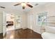 Bright living area with hardwood floors, ceiling fan, and doors to the kitchen and backyard at 3176 Duane Ave, Oldsmar, FL 34677