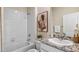 Bathroom featuring a shower-tub combo, granite countertop, and a framed vanity mirror at 32434 Osprey Peak Way, San Antonio, FL 33576