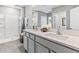 Bright bathroom featuring double sinks with modern fixtures and a walk-in shower with glass doors at 33091 Osprey Peak Way, San Antonio, FL 33576