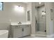 Modern bathroom featuring a walk-in shower with glass doors, a vanity with a sink, and a soaking tub at 3310 W Rogers Ave, Tampa, FL 33611