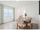 Dining room with a rustic wood table, seating for six, and a large window with light-filtering curtains at 33126 Osprey Peak Way, San Antonio, FL 33576
