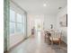 Bright dining room with a long wood table set for six, large windows, and neutral decor at 33126 Osprey Peak Way, San Antonio, FL 33576