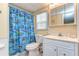 Bright bathroom features a vanity with a white cabinet, a patterned shower curtain and natural lighting at 35128 Dale Ave, Zephyrhills, FL 33541