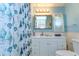 Bright bathroom with a white vanity, seashell shower curtain, and updated mirror and lighting at 35128 Dale Ave, Zephyrhills, FL 33541