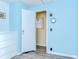 A blue bedroom with a closet, dresser, and accent clock with view of the room beyond at 35128 Dale Ave, Zephyrhills, FL 33541