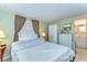 Serene bedroom with natural light, featuring a dresser and wardrobe for ample storage and an adjacent bathroom at 35128 Dale Ave, Zephyrhills, FL 33541