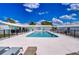 Zephyr Shores community pool with lounge chairs, black fencing, and tidy landscaping at 35128 Dale Ave, Zephyrhills, FL 33541