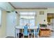 Charming dining area features a white table, blue chairs, and decorative window treatments, with a view of an adjacent room at 35128 Dale Ave, Zephyrhills, FL 33541