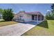 Neat single-story home with a long driveway leading to a covered patio and a screened-in porch at 35128 Dale Ave, Zephyrhills, FL 33541