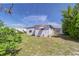 Exterior view of home with white siding, pink trim, grassy lawn, and a tree at 35128 Dale Ave, Zephyrhills, FL 33541