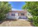 Cozy home nestled amongst trees with a covered porch and colorful shutters at 35128 Dale Ave, Zephyrhills, FL 33541