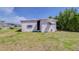 Exterior of single-story house with white siding and a well-maintained lawn surrounded by mature trees at 35128 Dale Ave, Zephyrhills, FL 33541