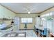 Inviting kitchen showcases light green cabinetry, sleek appliances, and a charming dining area with white table and blue chairs at 35128 Dale Ave, Zephyrhills, FL 33541
