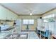 Well-lit kitchen features plenty of cabinet space, modern appliances, and a dining nook with a white table and blue chairs at 35128 Dale Ave, Zephyrhills, FL 33541