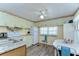 Cozy kitchen features abundant mint-green cabinets, a white refrigerator and dining area with round white table and blue chairs at 35128 Dale Ave, Zephyrhills, FL 33541